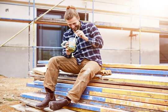 Happy worker having lunch break on a construction site