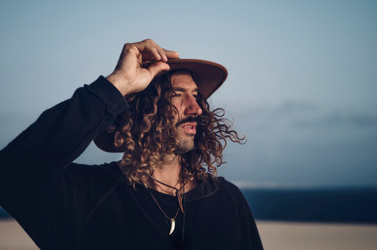 Young man with hat and mustache in the dunes