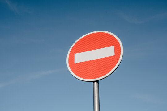 No entry sign board pole under blue sky