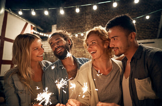 Freinds having a backyard party, burning sparklers