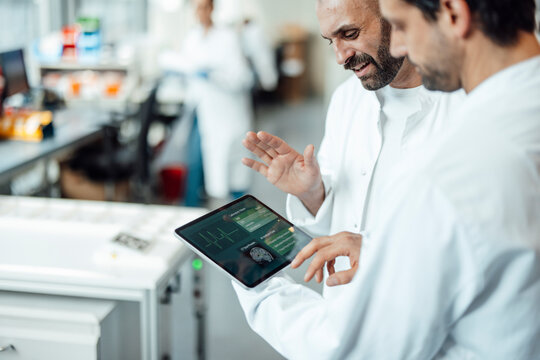 Medical team evaluating research graphics on a digital tablet