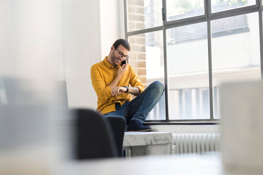 Young businessman in office talking on the phone