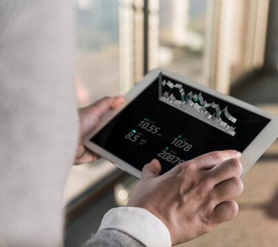 Woman using tablet with data emerging from screen