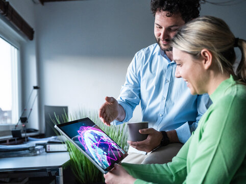 Colleagues discussing global data on a tablet in the office