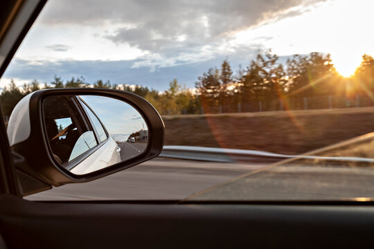 Voronezh, Voronezh Oblast, Russia, Shiny side-view mirror with sun setting in background