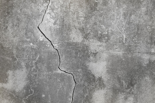 Scratched faded grunge surface of concrete wall with crack.