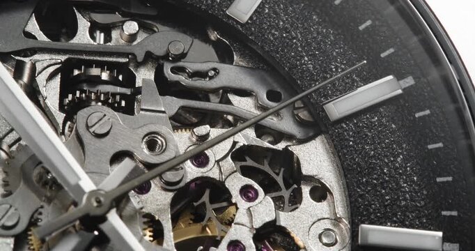 Macro close up of skeleton watch movement with gears turning and ticking hand