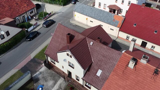 Roof renovation process with spray painting of roof tiles, including priming and applying second coat of paint on a residential roof, showing professional exterior maintenance and refurbishment work.