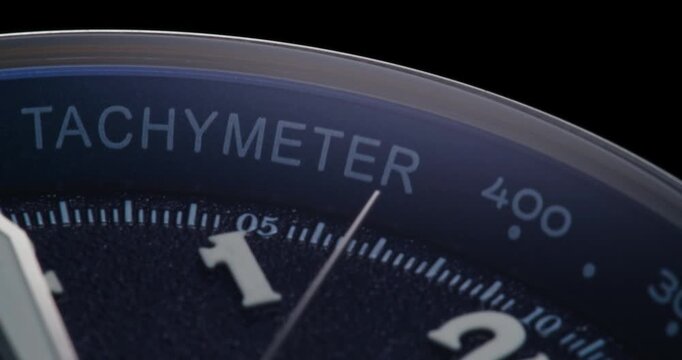 Macro close up of luxury watch dial with tachymeter bezel and sweeping second hand
