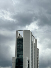Fototapeta premium Monolithic White Concrete Tower Under Gloomy Rain Clouds