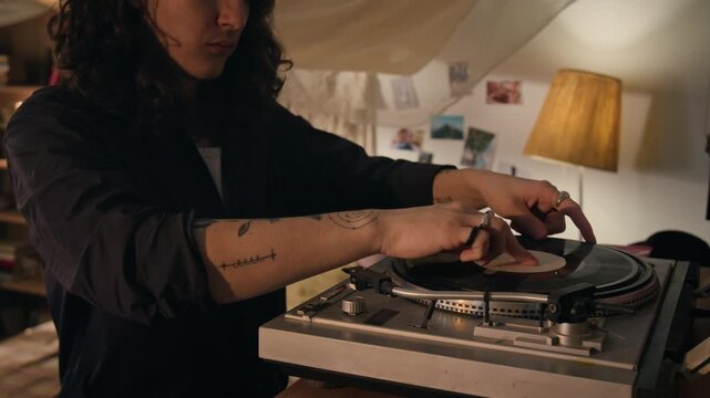 Young man placing vinyl record on turntable, walking to couch, and falling backward to relax. Ideal for music streaming services or youth lifestyle advertisements