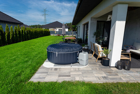 Private backyard garden featuring inflatable hot tub and green lawn