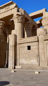 Kom Ombo temple ruins with double columns and composite capitals against clear blue sky in Egypt, ancient Ptolemaic architecture dedicated to Sobek and Horus with damaged walls