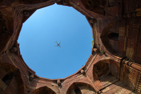 The Qutb Minar (Qutub Minar or Qutab Minar) details and an airplane in a clear sky. Qutb Minar is one of the major tourist magnets in New Delhi, the capital of India - Delhi, India