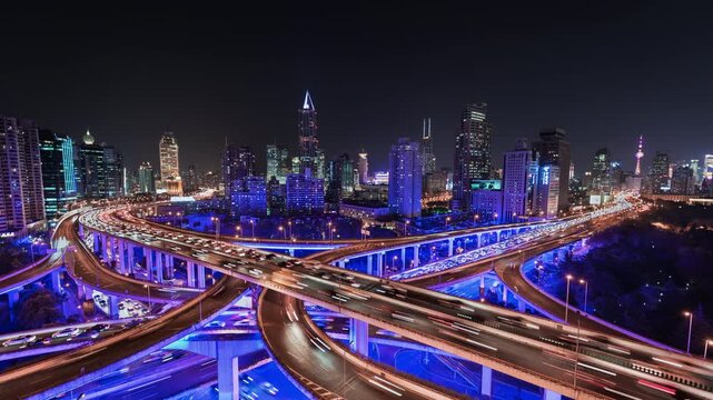 Time lapse of busy elevated road intersection with commuters with neon lighting, at night, Asia, China, Shanghai