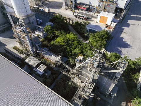 Aerial view of the Ergon Asfaltos Progreso industrial facility featuring silos, conveyor systems, and paved areas surrounded by lush greenery in Progreso, Yucatan, Mexico.