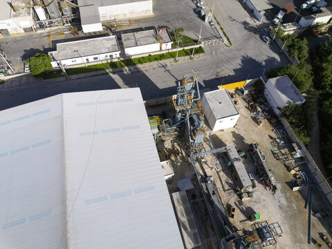 Aerial view of the Ergon Asfaltos Progreso industrial facility featuring large storage tanks, processing equipment, and a warehouse roof in Progreso, Yucatan, Mexico.