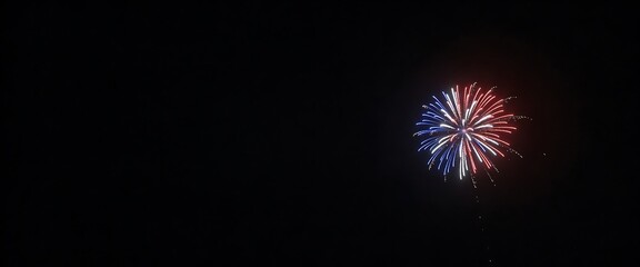 Fototapeta premium Red white and blue patriotic fireworks bursting against a vast black night sky panorama.