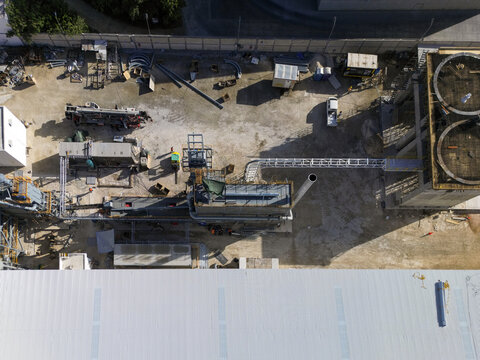 Aerial view of Ergon Asfaltos Progreso industrial facility showing storage tanks, processing equipment, and construction materials on site in Progreso, Yucatan, Mexico.