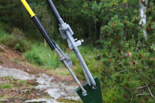 Guy wire turnbuckle tensioner attached to a ground mounting point. Stainless galvanized steel elements in Norway.