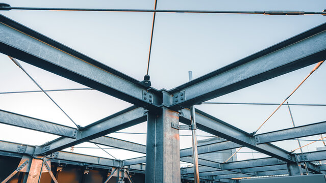 Steel structural beams forming geometric frame against overcast sky