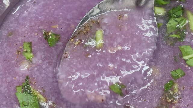 Close-up of stirring delicious purple taro soup in a bowl