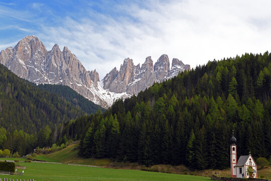 Church of San Giovanni in Ranui, an iconic baroque chapel located in Val di Funes, in South Tyrol. In the background stand the Odle (Geisler), a famous mountain group of the Dolomites, recognized as a