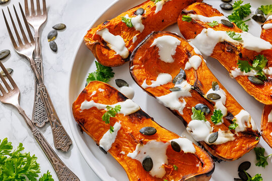 Baked butternut squash halves with yogurt sauce