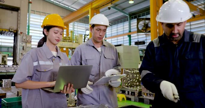 Asian female technician and two adult male engineers review laptop and sheet together, checking production detail, inspection note and workflow planning for teamwork in slow motion