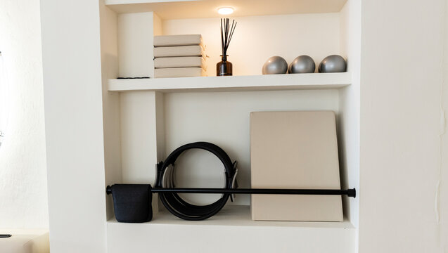 White interior niche displaying modern pilates and wellness items