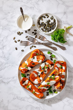 Baked butternut squash halves with yogurt sauce