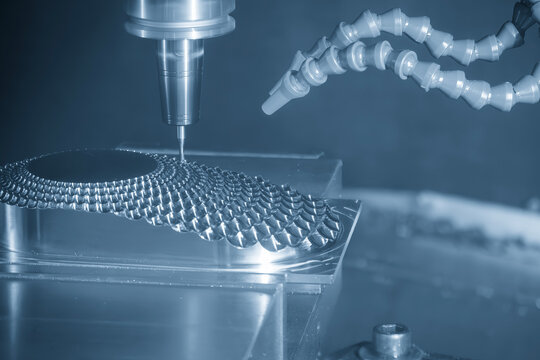 High-precision CNC milling machine performing a finishing cut on a reflector parts mold with a ball nose end mill tool.