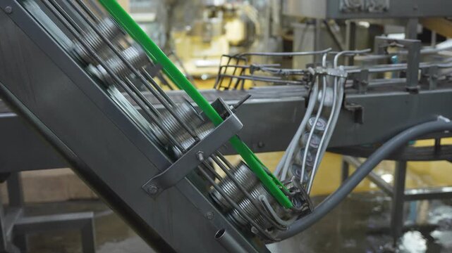 Canned food production line in a modern automated factory, Close-up of metal cans moving on a conveyor belt in a canning facility, Industrial food packaging process with automated metal can conveyor