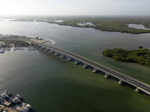 Aerial view of the Puerto de Abrigo bridge spanning the water with mangroves and boats in Progreso, Yucatan, Mexico.