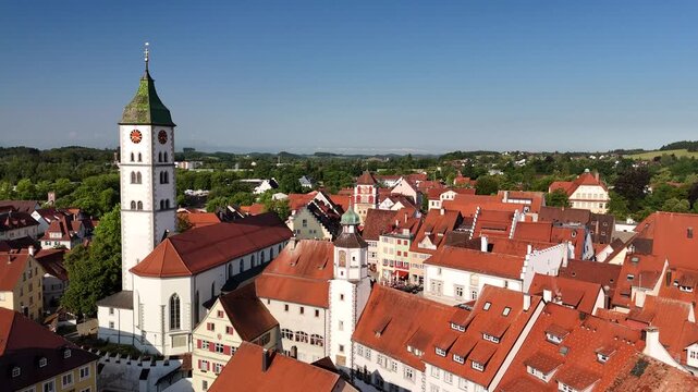 Aerial reveal of Wangen im Allgau town center and Alps, Drone rising up revealing the historic market square, traditional buildings and mountains on the horizon.