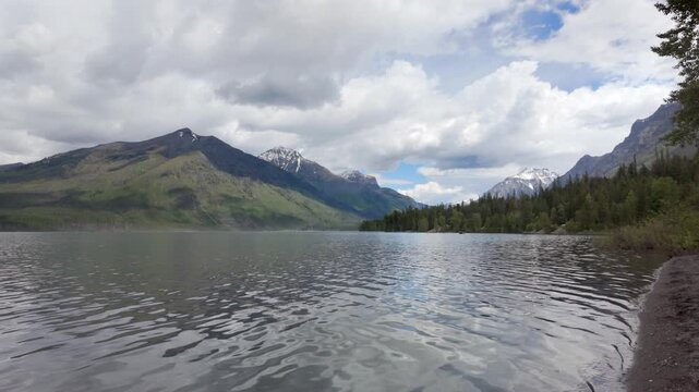 Slow motion shot of Lake McDonald and surrounding mountains in Glacier National Park, Montana on a sunny day.
