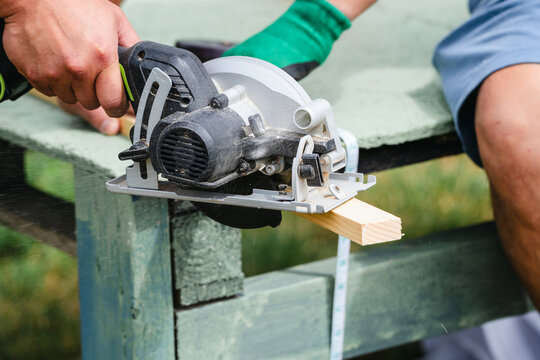 Close up of circular saw cutting wooden board during carpentry work