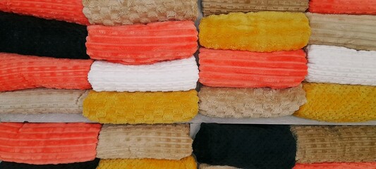 Colorful towels background A stack of rolled towels or blankets made from fine microfiber or fleece with a striped texture. The image can be used for backgrounds, wallpaper, designs, and more. © Abdurrahman Wayang 