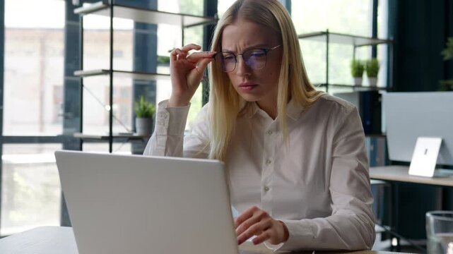 Caucasian business woman feeling confusion with bad broken glasses looking in laptop take of eyeglasses trying focusing on computer work girl female office businesswoman working blurry look in pc