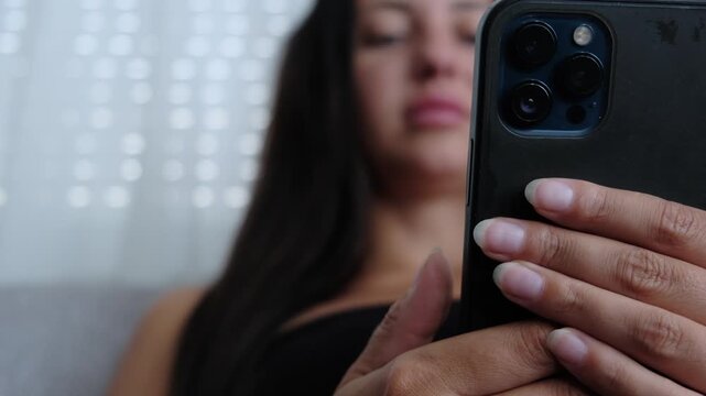 Social media addiction, compulsive scrolling and excessive screen time, young woman using smartphone on sofa at home, close up, modern digital lifestyle