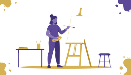 Fototapeta premium Woman standing next to an easel paints a picture on a blank canvas in an art studio with books and a wooden stool nearby.