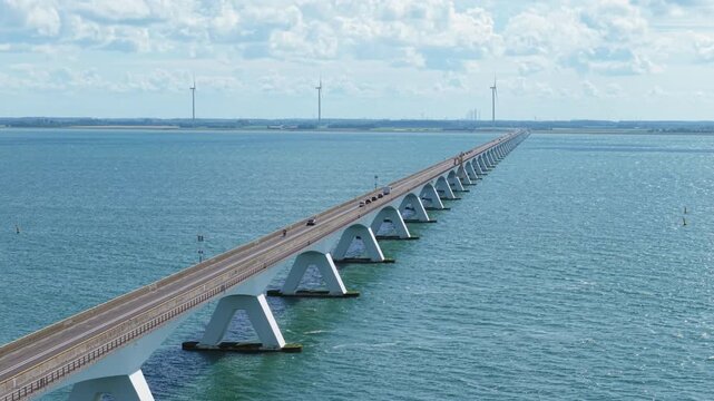 Cars driving on the Zeeland Bridge, a major engineering landmark connecting islands in the Netherlands over the Eastern Scheldt