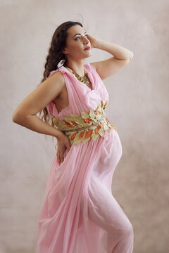Radiant Pregnant Woman as Greek Goddess in Pink Toga - Maternity Portrait