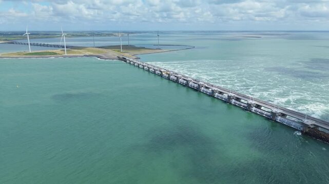 Eastern Scheldt storm surge barrier with flowing water and distant wind turbines in the Netherlands
