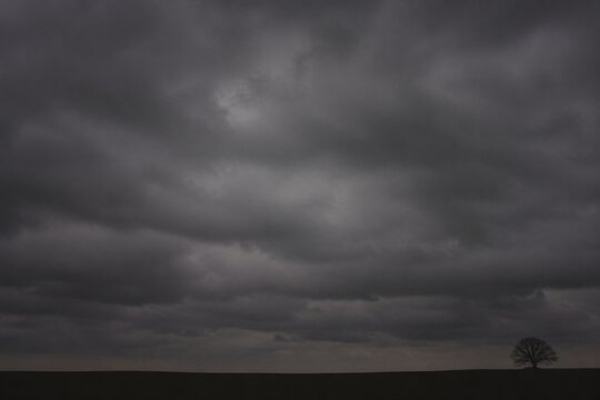 Heavy, overcast sky at dusk with thick gray clouds blocking the sun.