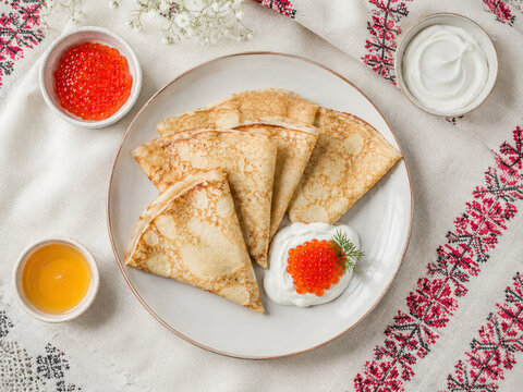  Cr&ecirc;pes finos servidos con caviar rojo, crema agria y miel, una combinaci&oacute;n cl&aacute;sica de la cocina eslava.