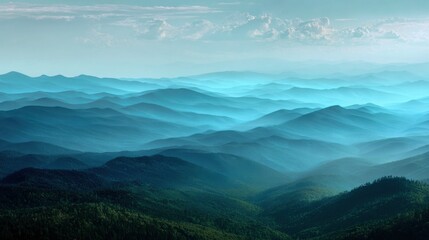 Fototapeta premium Panoramic view of rolling blue mountain ridges covered in layers of morning mist