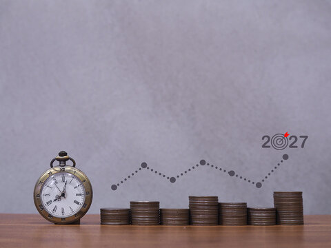 Vintage watch, Stack of coins with graph. The concept of business growth, Financial investment, Market stock, Profit return, Dividend and Business fund in year 2027