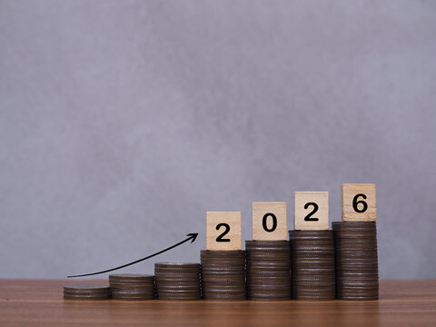 Wooden blocks with the number 2026 on stack of coins with arrow rising. The concept of saving money, Financial, Investment and Business growing in year 2026.