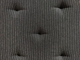 Fototapeta premium Close up of black stripes fabric with recessed embossed button. Suitable for sofa cushion backing, padded, and upholstered panel. Seamless background texture.